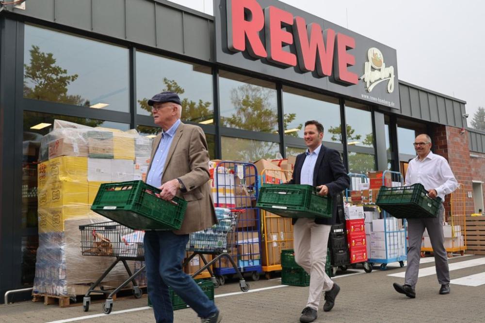 Lions Mitglieder tragen Sach- und Lebensmittelspenden aus dem REWE Markt Höchsten